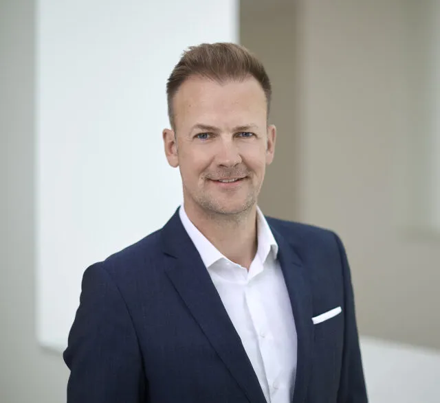 Bild von Dr. Florian Fuhrmann im blauen Anzug mit weißem Hemd