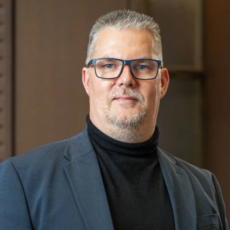 Mann mit grauen kurzen Haaren und Brille